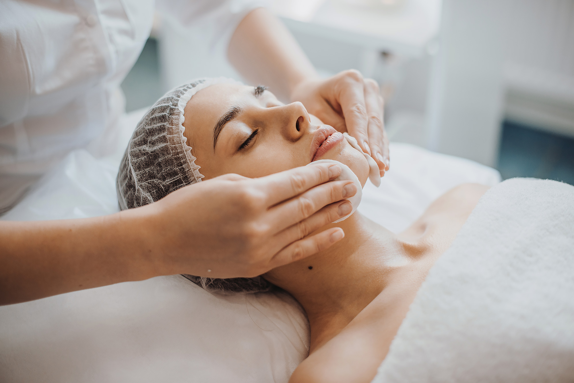 Person receiving a neck massage from a therapist in a serene setting.