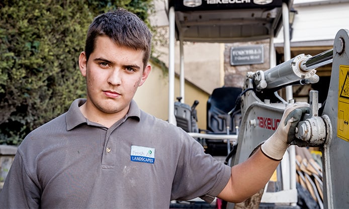 A worker in a polo shirt operating heavy machinery.