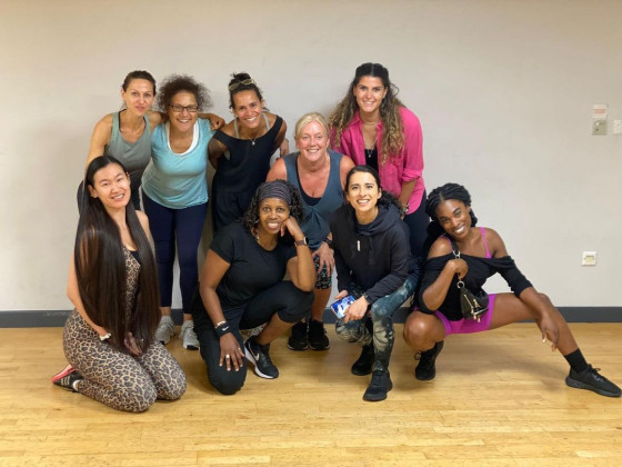 Group of people in athletic wear posing together in a fitness studio.