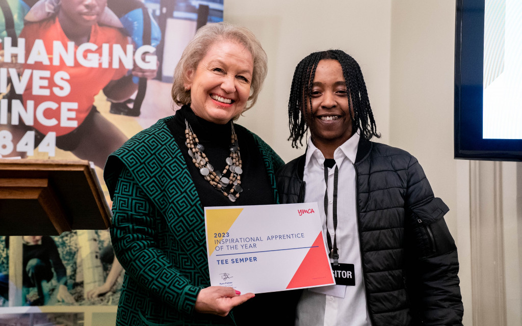 Two individuals holding an award certificate for "2023 Inspirational Apprentice of the Year."