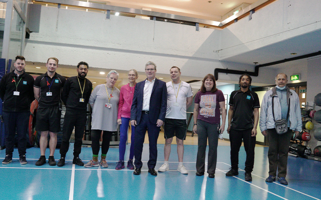 Group of people standing in an indoor sports facility.