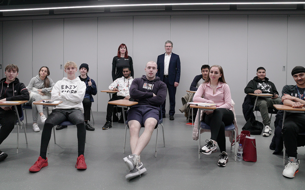 Students seated in a classroom with a standing instructor to the right.