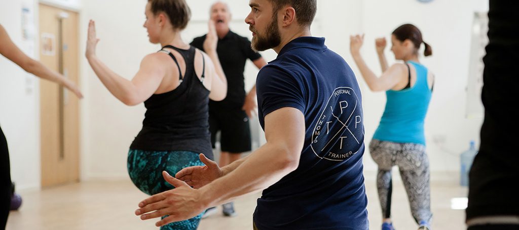 Group of people participating in an exercise class indoors.